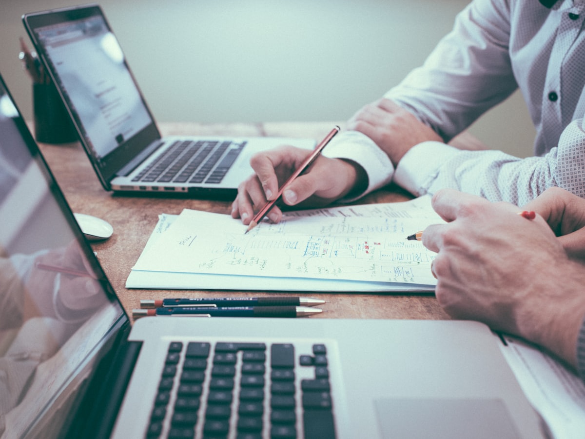 Designer reviewing homepage mockups on a large display, brand color swatches on the desk